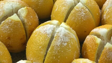 Preparing preserved lemons. close-up of cross-cut lemons sprinkled with non-iodized salt.
