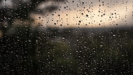 Raindrops on the glass close-up, rainy day, blurred background