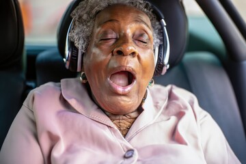 old woman sleeping, grandmother sleeps, elderly person asleep, woman with headset, person sitting in a car, black senior female