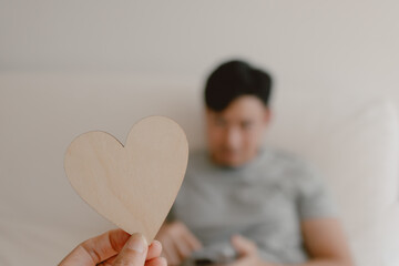 Photo of woman hand holding wooden blank empty space of heart design, showing and giving to asian man, showing love gesture, lovely couple marriage, valentines concept.