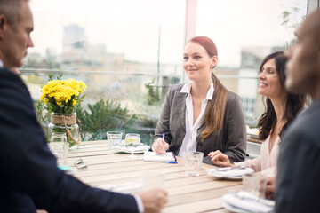 Businesswoman during meeting at restaurant with colleagues