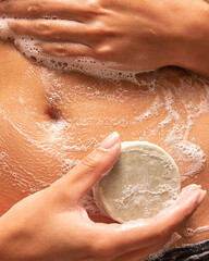 woman washing body with solid soap