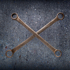 A crosssed pair of old boxend wrenches showing the patina of many years of use.