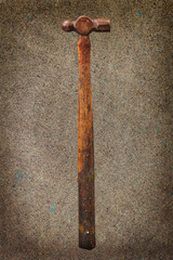 A small, slightly rusty ball peen hammer proudly wears its decades old patina that attests to reliability and utility through the years.