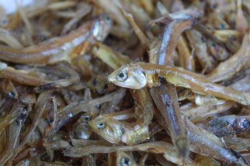 Background texture of dried anchovy fish, uncooked. Preserved with salt