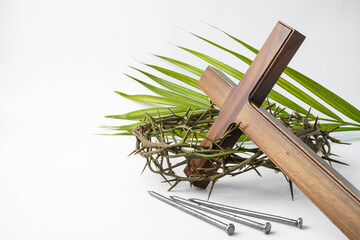 Jesus Wooden cross with nails, palm leaves and Crown of Thorns. Catholic Christians Good Friday Ceremony. Isolated on white background with empty blank copy text space. - obrazy, fototapety, plakaty