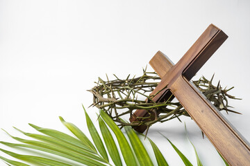 Illustration of Jesus Wooden cross with palm leaves and Crown of Thorns used by Catholic Christians on Good Friday Ceremony. Isolated on white background with empty blank copy text space.
