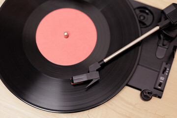 Top view of vintage portable record player playing a black vynil record