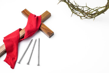 Jesus Wooden cross wrapped with red cloth next to nails and Crown of Thorns used by Catholic Christians on Good Friday Ceremony. Isolated on white background with empty blank copy text space. - obrazy, fototapety, plakaty