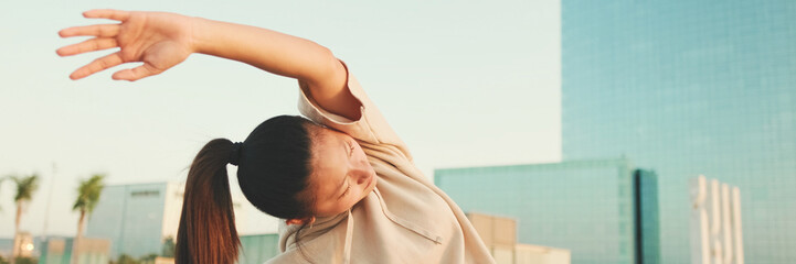 Close-up, Asian girl in sportswear doing workout at morning time, stretching on modern buildings...