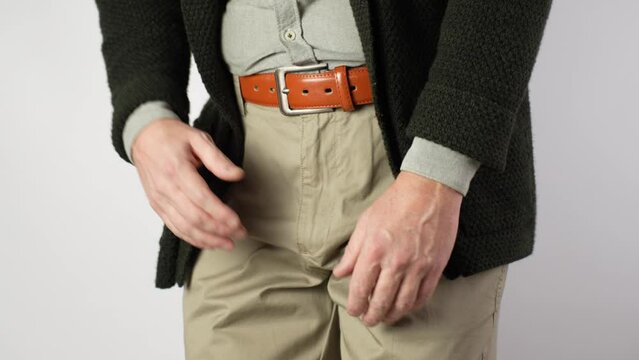 A man suffers from pain in the pelvic organs, close-up.