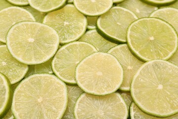 Many juicy lime slices as background, above view