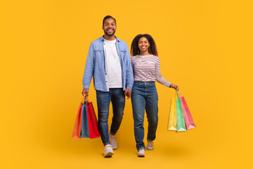 Portrait Of Happy African American Couple Walking With Bright Shopping Bags
