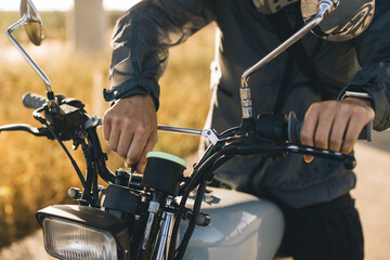 Biker man starts his motorcycle by turning the ignition key. Concept of riding a motorcycle at...