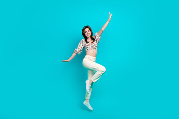Fototapeta na wymiar Full length photo of cute impressed woman wear flower print top jumping high arms sides isolated teal color background