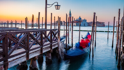 Serene Dawn over Venice with Gondola Blurring in Motion by Wooden Docks Moored by Saint Mark Square with San Giorgio di Maggiore Church in Background, Venice, Italy - obrazy, fototapety, plakaty