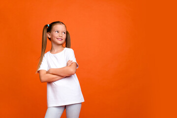 Photo portrait of cute little lady promo look empty space crossed hands dressed stylish striped garment isolated on orange color background