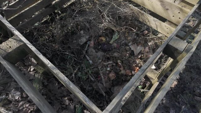Woodnen pallet composter in garden. Filmed in log color profile. 4K