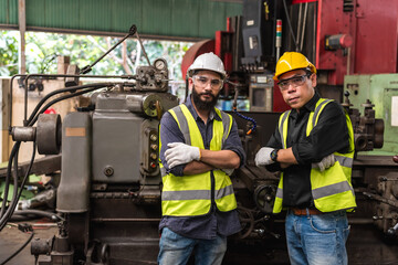 Factory engineer man and senior technician colleague working together in industrial heavy machinery 