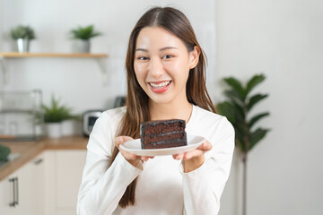 Portrait of attractive pretty girl, asian young teenage woman holding plate of a piece of chocolate...