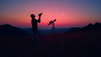 Astronomer with a camera photographing night skies. - obrazy, fototapety, plakaty