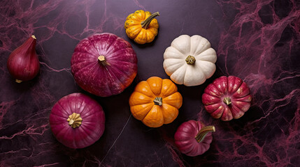 A group of pumpkins on a dark magenta color marble