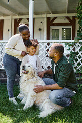 cheerful african american family playing with dog on backyard of their house, quality time
