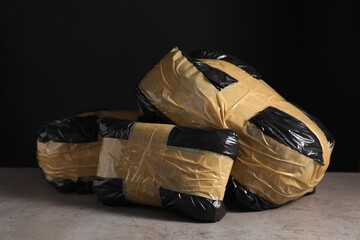 Smuggling and drug trafficking. Packages with narcotics on grey table against black background