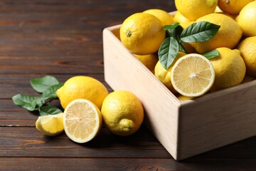 Fresh lemons in crate on wooden table