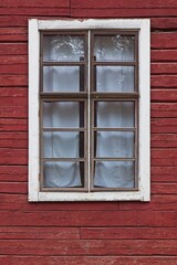 White framed window on old red painted wood wall.