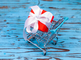 Gift box with silk bow in shopping cart - 740878193