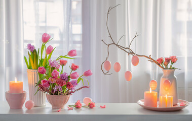 easter home decor with flowers, eggs, burning candles