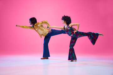 Full length portrait of talented people, dancers duo energetically moves against gradient pink...