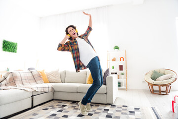 Full length photo of excited cheerful guy dressed checkered shirt dancing listening music...