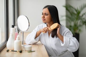 Angry young indian woman having problem of her thick hair