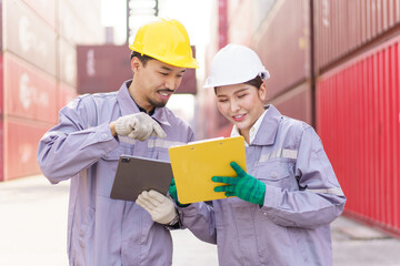 Asian male and female customs officers are currently conducting inspections of containers within...