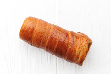 Traditional Hungarian donuts (Kürtöskalács), commonly known as chimney cake, on a white wooden background from above view, with selective focus.