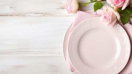 Light pastel colored tableware set: plate, vintage silverware on napkin and delicate pink roses on rustic shabby wooden background with copy space. Top view - obrazy, fototapety, plakaty