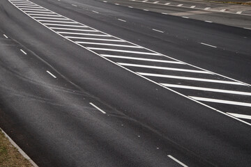 Asphalt road background with white road marking lines. Renewed asphalt surface, street repair concept