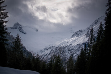 wandering in the beautiful alps, the hohe tauern in the national park austria, at a cloudy and sunny winter day