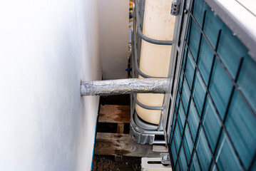 Outdoor unit of a low-power air heat pump located in front of the house.