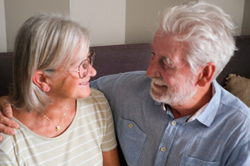 Mature couple in romantic indoor leisure activity at home bonding and looking each other with smile and love. People senior lifestyle. Elderly male and female married in relationship. Serene retired