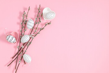 Easter holiday composition. Pussy willow branches decorated easter eggs on pink background. Minimal...