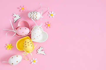 Easter holiday composition. Easter eggs, decorations, bunny, flowers, isolated on pastel pink background. Easter concept. Flat lay, top view, copy space 