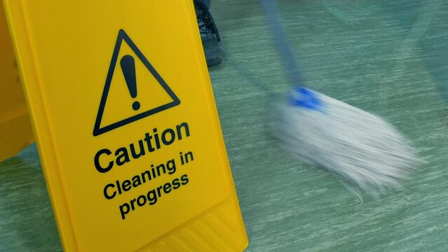 Person Mops Floor By Safety Sign 2 Shots