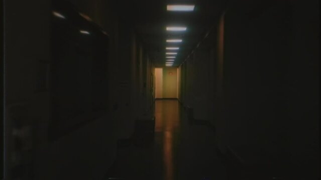 Walking Through Dark Corridor Retro VHS Effect Eerie Hallway Tracking Shot. Walking through an eerie dark corridor flickering lights, retro VHS effect. Tracking shot