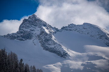 wandering in the beautiful alps, the hohe tauern in the national park austria, at a cloudy and sunny winter day
