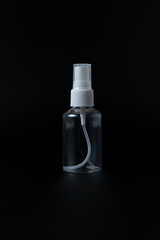 Small transparent plastic spray bottle on black background