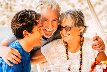 Cheerful happy family celebrate together at lunch hugging and smiling - mixed generations ages with...