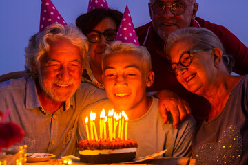 Grandfathers senior people and young teenager celebrate birthday together by night at home with...